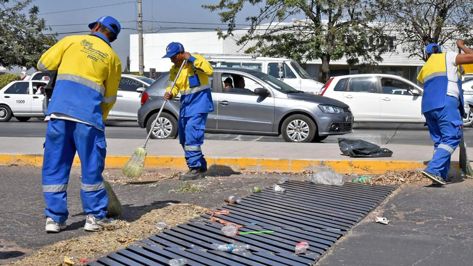 trabajadores limpian coladera